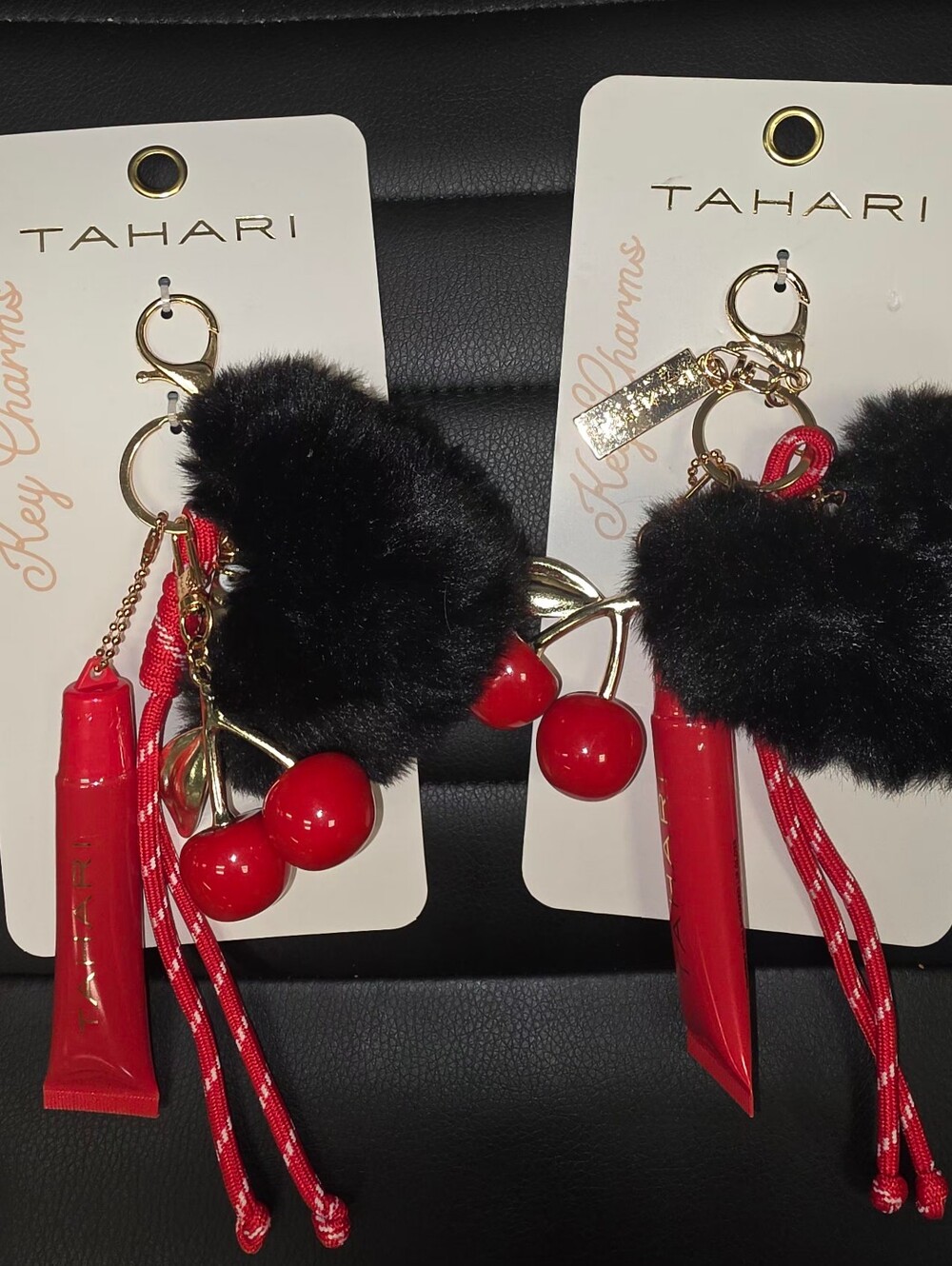 Tahari cherry and pom-pom keychain features a vibrant red Pompom & Lip Balm 1
